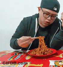 Man In Glasses And Hat Eating Noodles With Chopsticks GIF