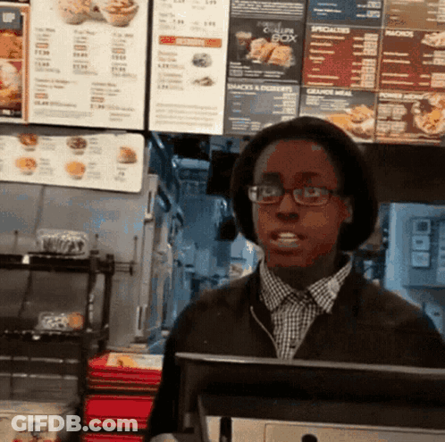 Man In Glasses And Hat In Front Of Chicken Box Menu GIF