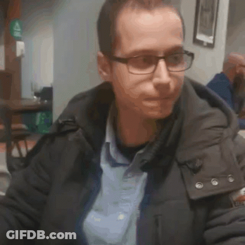 Man In Glasses And Jacket Sitting In Restaurant GIF