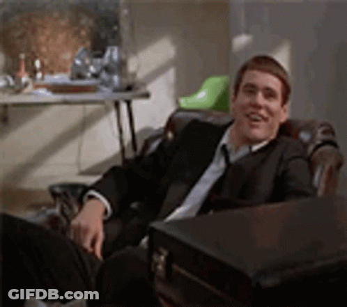 Man In Glasses And Name Tag In Front Of White Building GIF