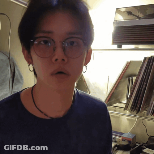 Man In Glasses And Necklace By Record Player GIF
