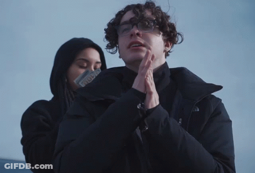 Man In Glasses And North Face Jacket Next To Woman GIF