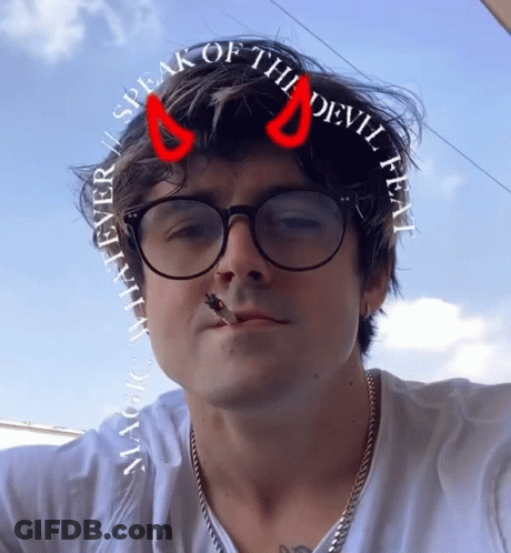 Man In Glasses And Red Horns Saying Speak Of The Devil GIF