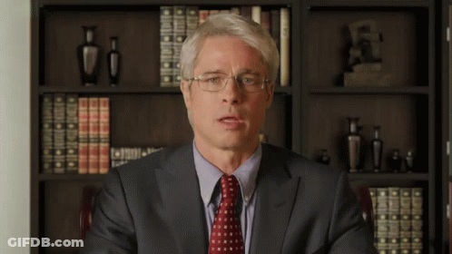 Man In Glasses And Suit In Front Of Bookshelf GIF