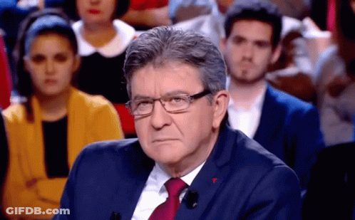 Man In Glasses And Suit Sitting In Front Of Crowd GIF