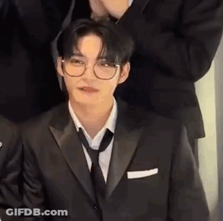 Man In Glasses And Suit Sitting With Group GIF