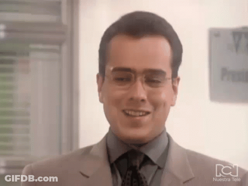 Man In Glasses And Suit Smiling By Nuestra Tele Sign GIF