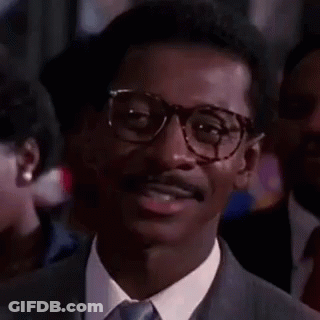 Man In Glasses And Suit Smiling In Crowd GIF