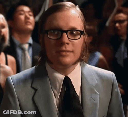 Man In Glasses And Suit Standing In Crowd GIF
