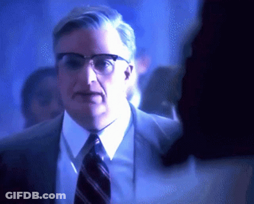 Man In Glasses And Suit Standing In Crowd GIF