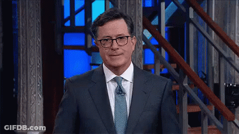 Man In Glasses And Suit Standing In Front Of Stairs GIF