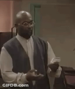 Man In Glasses And Vest Holding Something GIF