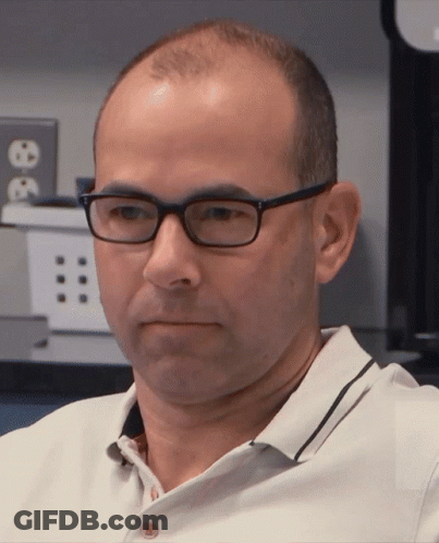 Man In Glasses And White Shirt Looking At Camera GIF