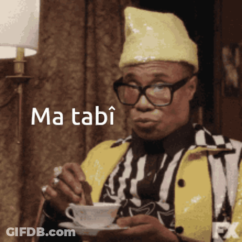 Man In Glasses And Yellow Hat Holding Coffee Ma Tabi GIF