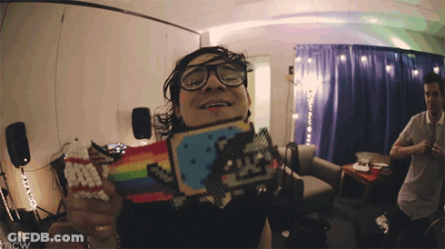 Man In Glasses Holding Rainbow Cat Toy GIF