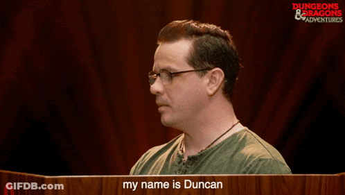 Man In Glasses In Front Of My Name Is Duncan Sign GIF