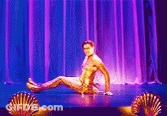 Man In Gold Outfit Sitting On Stage GIF