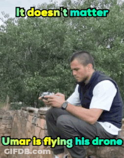 Man In Gold Robe Standing Next To Bearded Man In Chair GIF