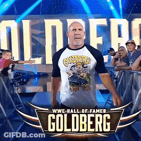 Man In Goldberg Shirt In Front Of WWE Hall Of Fame Sign GIF