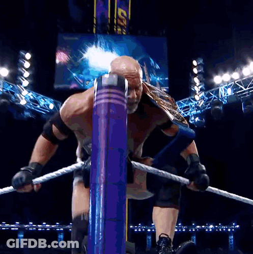 Man In Goldberg Shirt In Front Of WWE Hall Of Fame Sign GIF