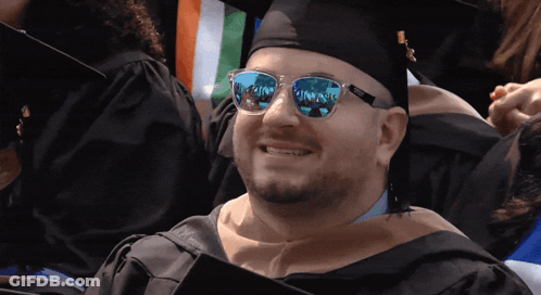 Man In Graduation Cap And Gown With Sunglasses Reflecting Paradise GIF
