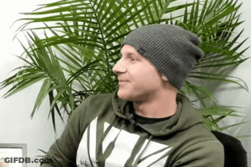 Man In Gray Beanie And Green Hoodie With Letter V GIF