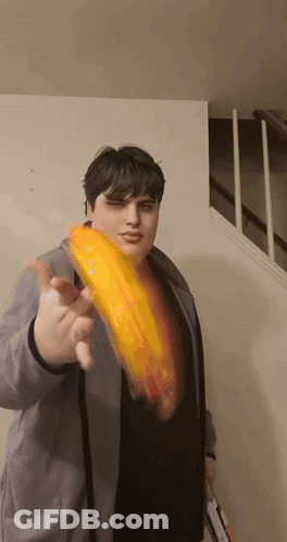 Man In Gray Jacket Holding Yellow Object GIF
