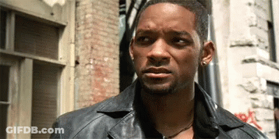 Man In Gray Shirt Making Funny Face At Table GIF