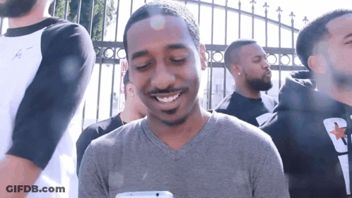 Man In Gray Shirt Smiling At Phone GIF