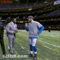 Man In Gray Shirt Talking To Man In Suit On Football Field GIF