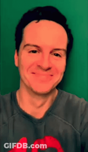 Man In Gray Shirt With Red Heart Smiling GIF