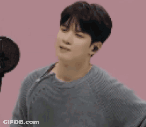 Man In Gray Sweater At Microphone GIF