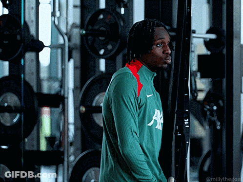 Man In Green Allianz Shirt In Front Of Gym Machine GIF