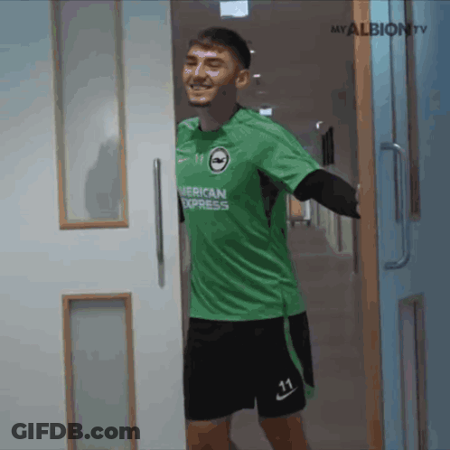 Man In Green American Express Jersey Standing In Hallway GIF