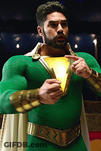 Man In Green And Gold Superhero Costume Holding Light GIF