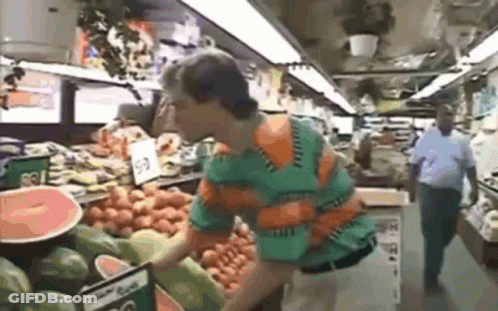 Man In Green And Orange Shirt Looking At Watermelons GIF