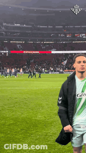 Man In Green And White Jersey Saying Gro On Soccer Field GIF