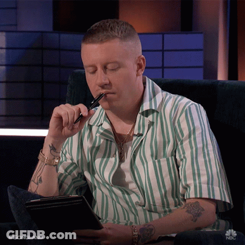 Man In Green And White Striped Shirt Holding Pen To Mouth GIF