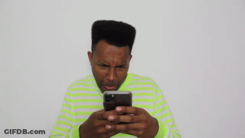 Man In Green And White Striped Shirt Looking At Cell Phone GIF