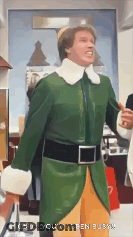 Man In Green And Yellow Elf Costume Standing In Store GIF