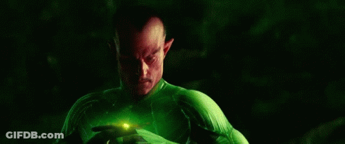 Man In Green And Yellow Superhero Costume Holding Green Object GIF