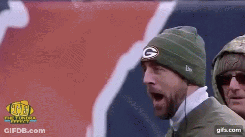 Man In Green Bay Beanie Screaming Near Red And White Flag GIF