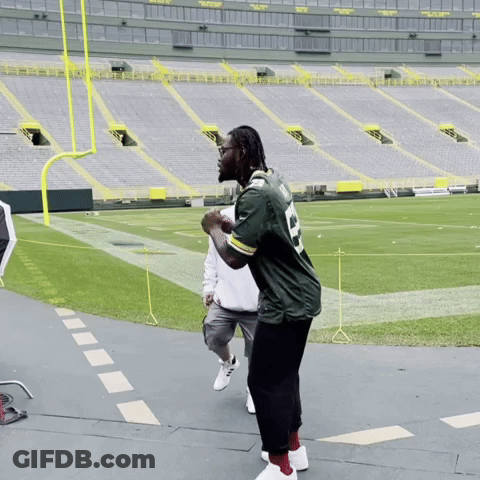 Man In Green Bay Packers Jersey On Stadium Floor GIF
