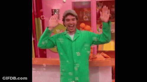 Man In Green Coat Surrounded By Soap Bubbles GIF