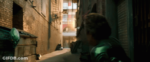 Man In Green Costume Walking Alleyway GIF