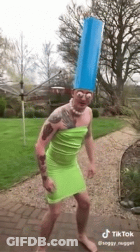 Man In Green Dress And Blue Hat Dancing In Garden GIF