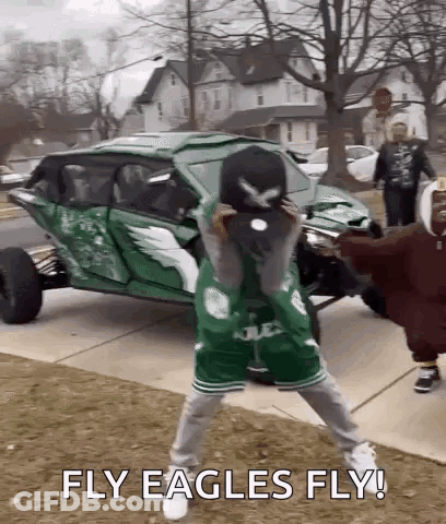 Man In Green Eagles Jersey Holding Baseball Cap In Front Of Green Vehicle GIF