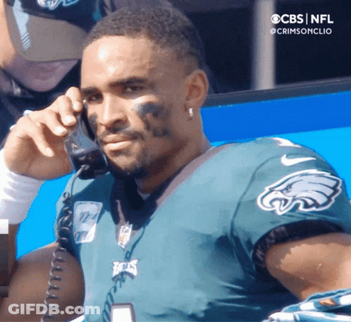 Man In Green Eagles Jersey Talking On Phone GIF