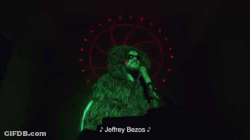 Man In Green Fur Coat Singing Into Microphone Jeffrey Bezos GIF