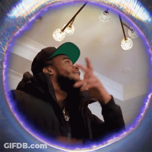 Man In Green Hat And Black Jacket Looking Up GIF